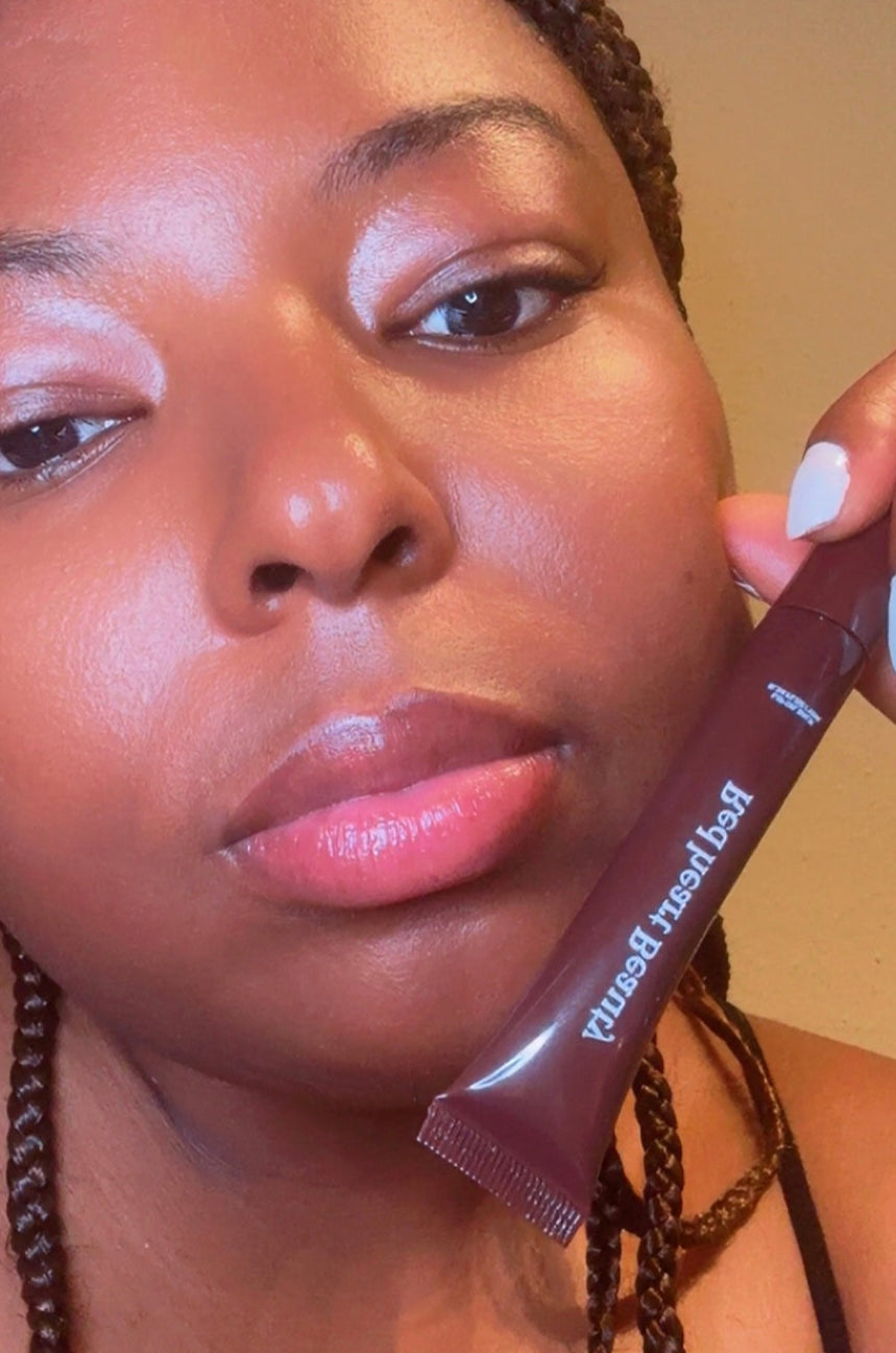 Woman holding a brown tube with visible text against a neutral background