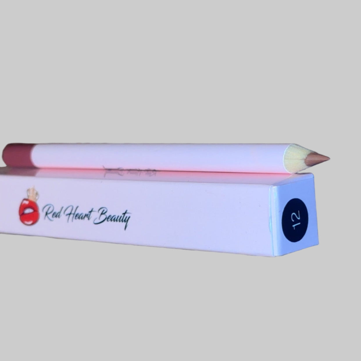 Lip liner pencil with packaging on a textured surface